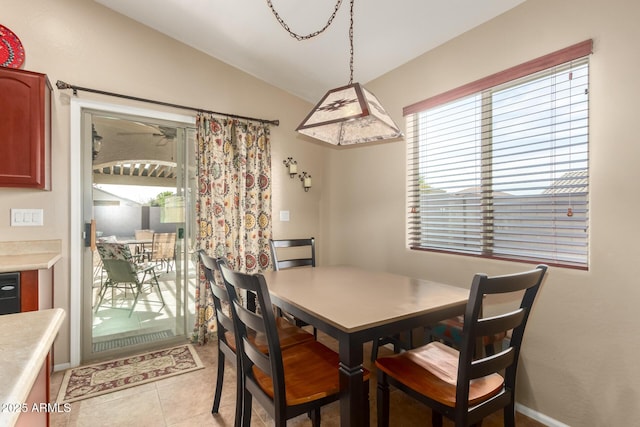 dining area featuring light tile patterned flooring and lofted ceiling