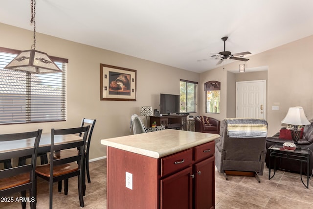 kitchen featuring a center island, vaulted ceiling, hanging light fixtures, light tile patterned floors, and ceiling fan