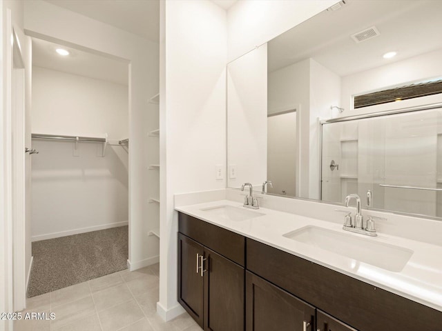 3550 N Camden Dr, Florence, AZ 85132 - full bath with double vanity, a walk in closet, a shower stall, recessed lighting, and tile patterned floors