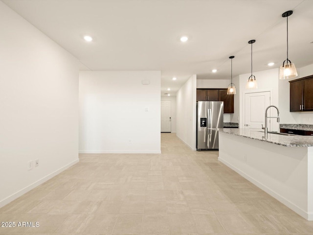 3550 N Camden Dr, Florence, AZ 85132 - kitchen featuring stainless steel fridge, dark brown cabinets, recessed lighting, light stone countertops, and decorative light fixtures