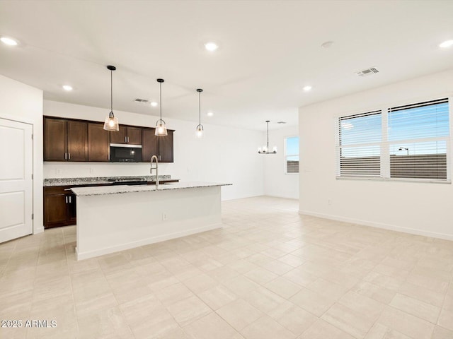 3550 N Camden Dr, Florence, AZ 85132 - kitchen featuring stainless steel microwave, recessed lighting, a chandelier, dark brown cabinetry, and an island with sink