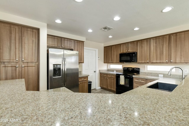 1072 W Windhaven Ave, Gilbert, AZ 85233 - kitchen with black appliances, a sink, light stone countertops, brown cabinets, and recessed lighting