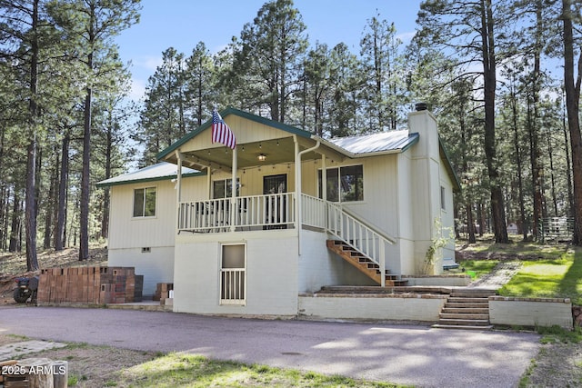 3017 Larson Loop, Forest Lakes, AZ 85931 - view of front of home featuring stairway, metal roof, and a chimney