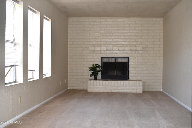 unfurnished living room with carpet flooring and a fireplace