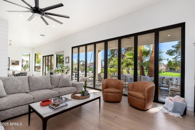 living room featuring ceiling fan and light wood-type flooring