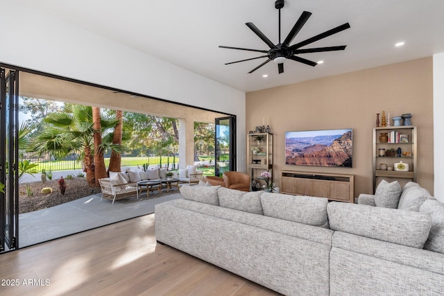 living room with a wealth of natural light, ceiling fan, and hardwood / wood-style flooring