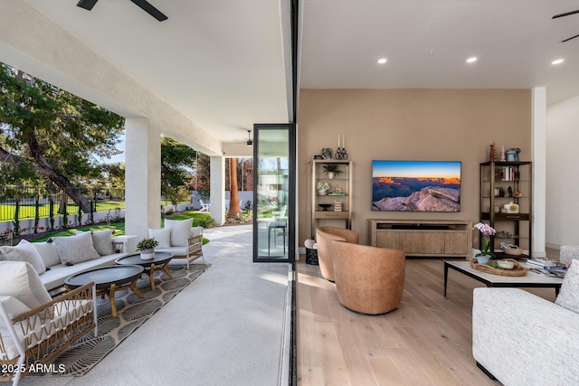 living room featuring light hardwood / wood-style floors and ceiling fan