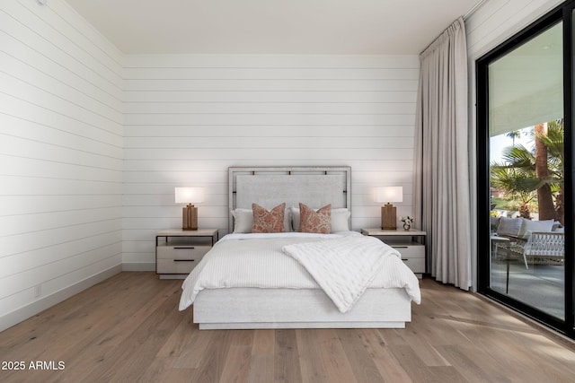 bedroom with light hardwood / wood-style floors and access to exterior