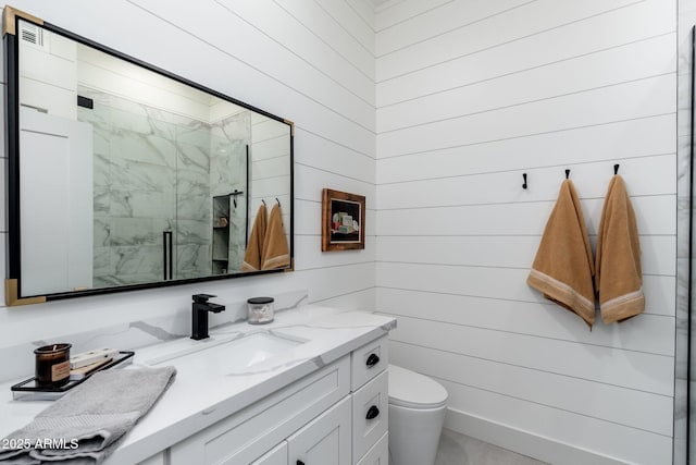 bathroom featuring vanity, wood walls, toilet, and walk in shower