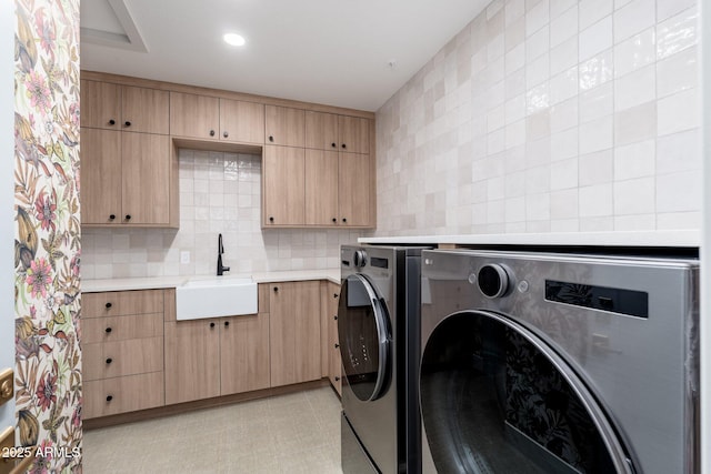 laundry room with separate washer and dryer, sink, and cabinets