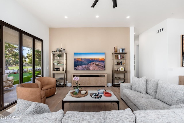 living room featuring ceiling fan and light hardwood / wood-style flooring