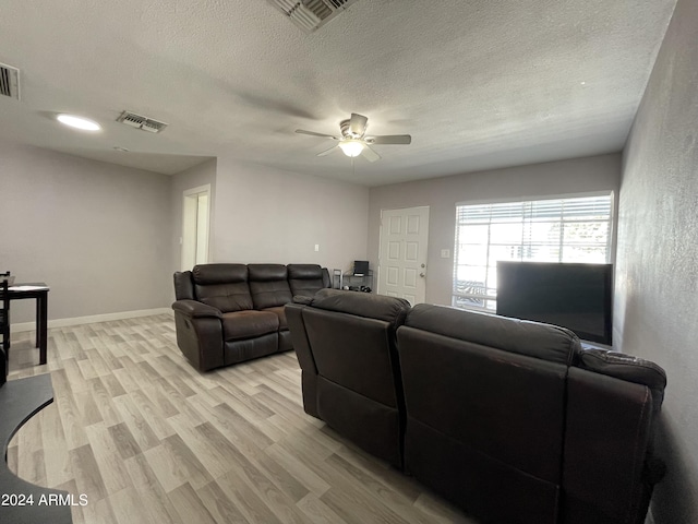 living area with ceiling fan, light wood-style flooring, visible vents, and baseboards