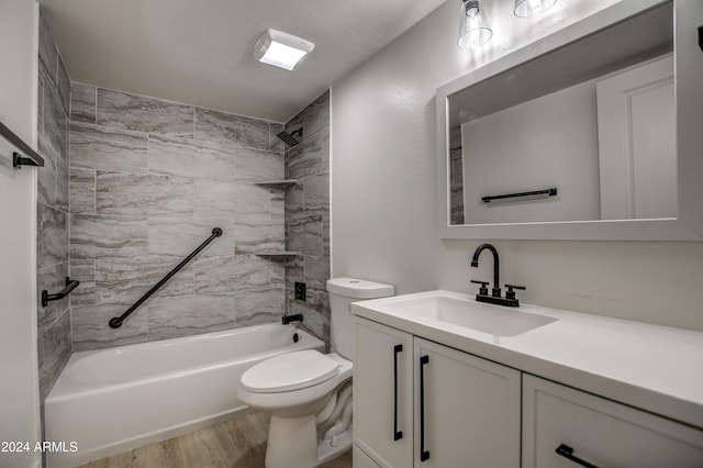 full bathroom featuring vanity, tiled shower / bath combo, hardwood / wood-style flooring, and toilet