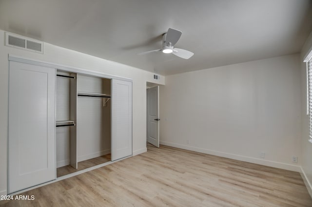 unfurnished bedroom featuring ceiling fan, light hardwood / wood-style floors, and a closet