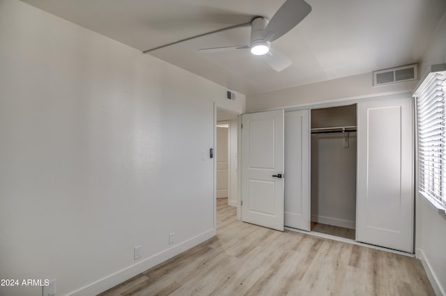 unfurnished bedroom with ceiling fan, light wood-type flooring, and a closet