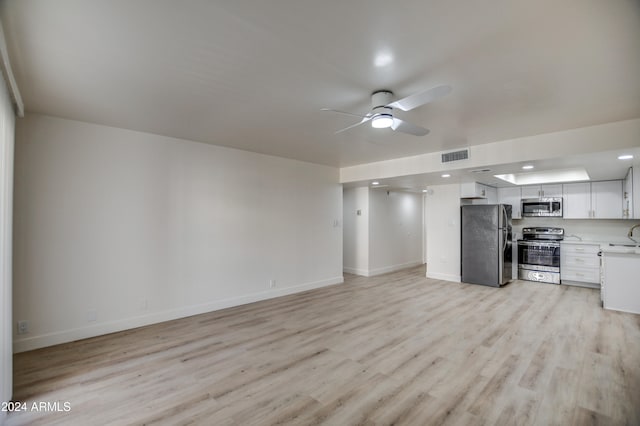 unfurnished living room featuring ceiling fan and light wood-type flooring