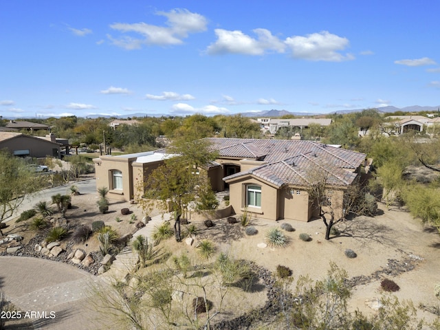 mediterranean / spanish-style house with a tiled roof, a residential view, and stucco siding