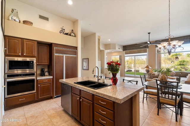 kitchen with built in appliances, a kitchen island with sink, a sink, visible vents, and open floor plan