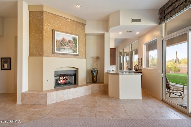 interior space with a tile fireplace and visible vents