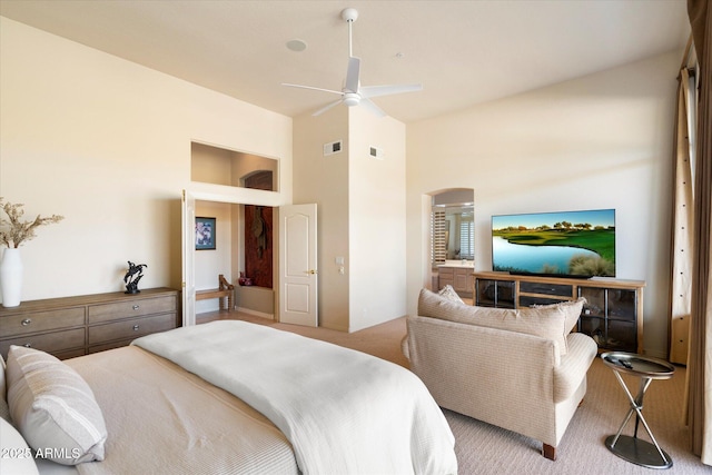 bedroom featuring light carpet, high vaulted ceiling, arched walkways, and visible vents