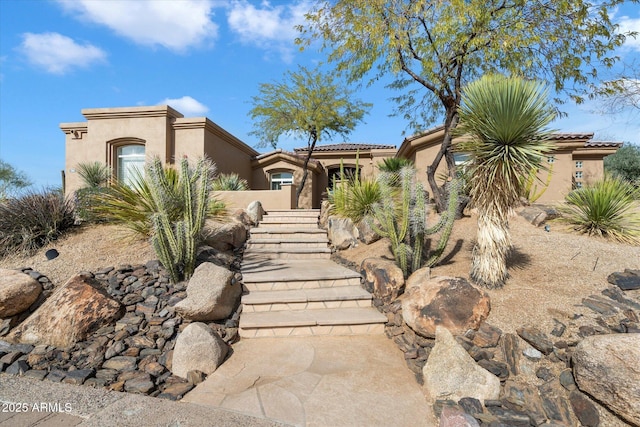 view of front of property with a tiled roof and stucco siding