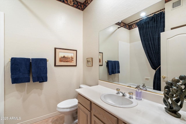 bathroom featuring baseboards, visible vents, vanity, and toilet