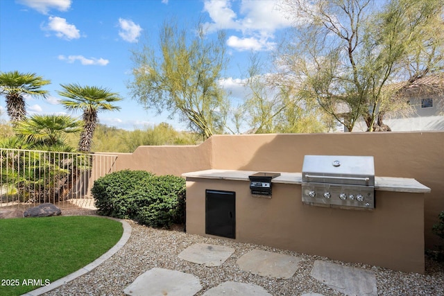 view of patio with area for grilling, an outdoor kitchen, and fence