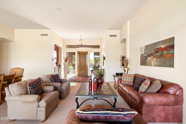 living room featuring an inviting chandelier, visible vents, and arched walkways