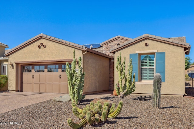 view of front of home with a garage and solar panels