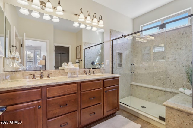 bathroom featuring a shower with door, vanity, plenty of natural light, and tile patterned flooring