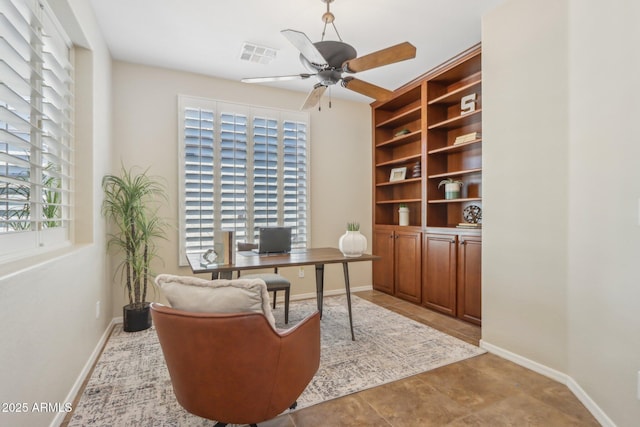 home office with plenty of natural light, ceiling fan, and built in shelves