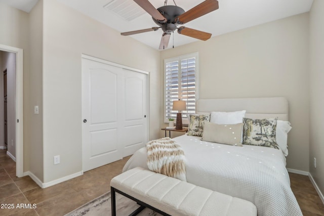 tiled bedroom with ceiling fan and a closet