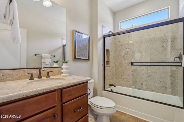 full bathroom featuring vanity, combined bath / shower with glass door, tile patterned floors, and toilet