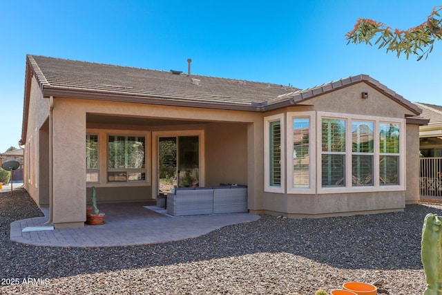 back of property with an outdoor living space and a patio