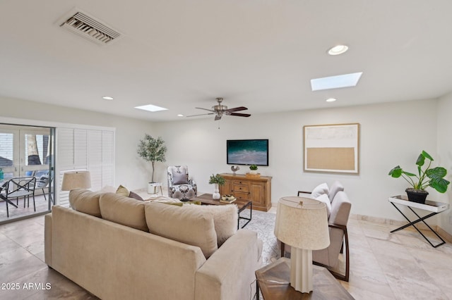 living room with light tile patterned floors, ceiling fan, and a skylight