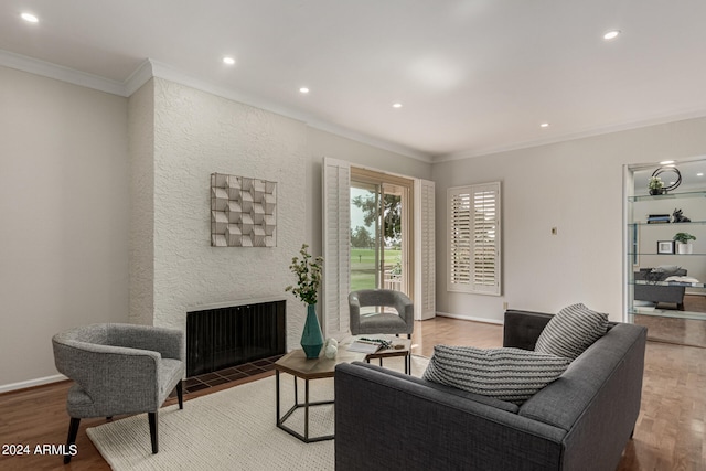 living room featuring hardwood / wood-style flooring, a fireplace, and crown molding