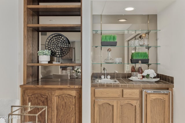 bar featuring tile counters and sink