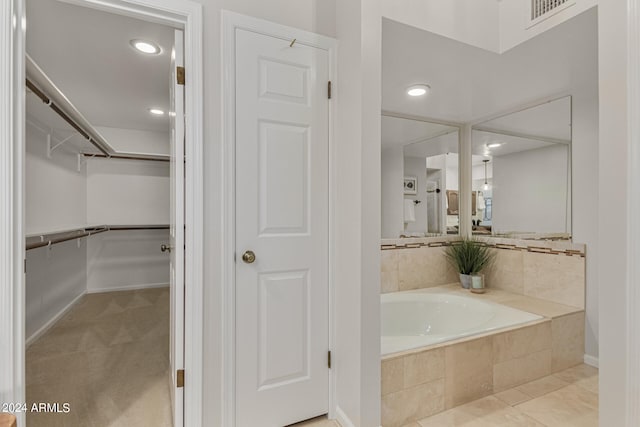 bathroom featuring tiled tub and tile patterned floors