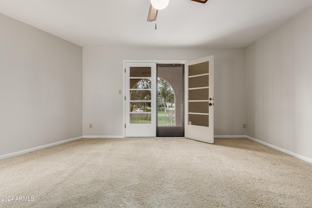 carpeted spare room featuring ceiling fan