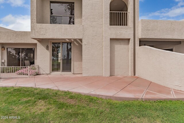 rear view of property with a lawn and a patio