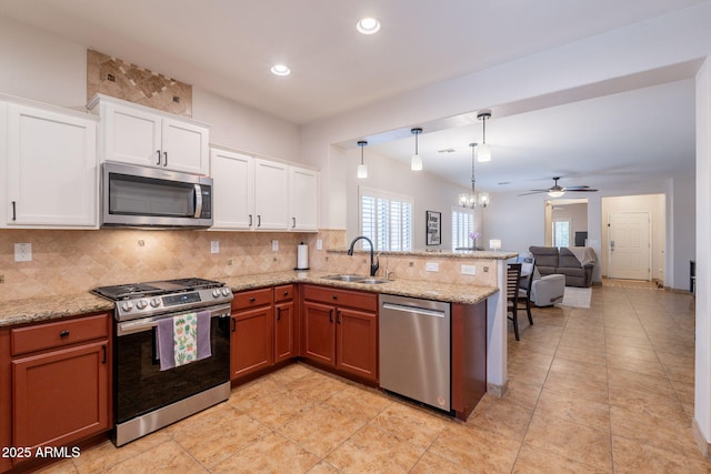 1927 W Mine Trl, Phoenix, AZ 85085 - kitchen with appliances with stainless steel finishes, a peninsula, backsplash, a chandelier, and open floor plan