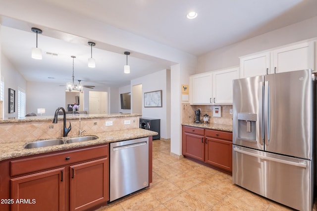 1927 W Mine Trl, Phoenix, AZ 85085 - kitchen featuring appliances with stainless steel finishes, tasteful backsplash, decorative light fixtures, light stone counters, and white cabinetry