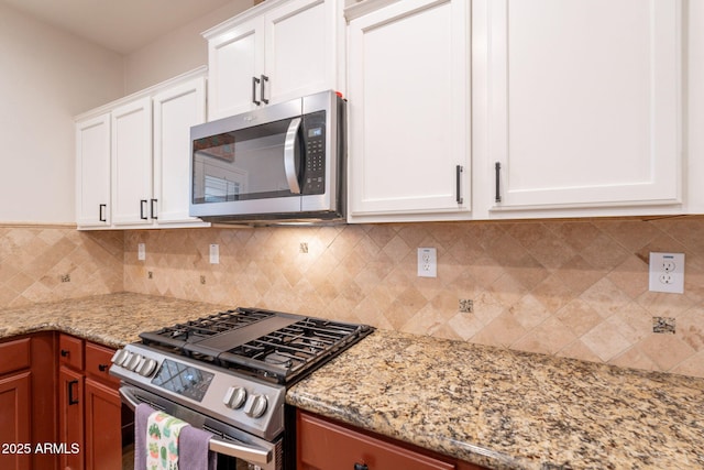 1927 W Mine Trl, Phoenix, AZ 85085 - kitchen with stainless steel appliances, white cabinets, tasteful backsplash, and light stone counters