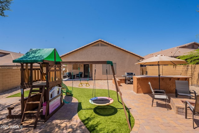 1927 W Mine Trl, Phoenix, AZ 85085 - rear view of house with stucco siding, a fenced backyard, a playground, and a patio
