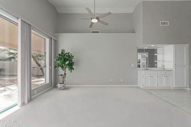 unfurnished room featuring ceiling fan, light colored carpet, high vaulted ceiling, and sink