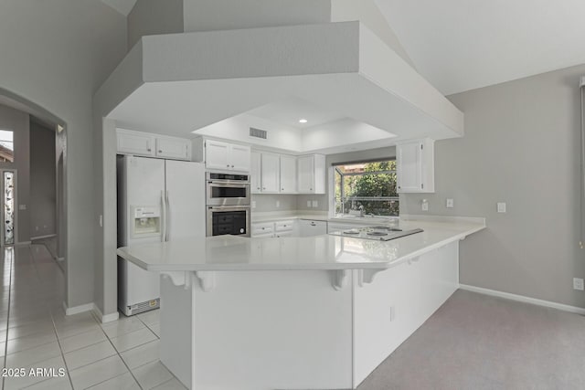 kitchen featuring white cabinets, white refrigerator with ice dispenser, black electric cooktop, and kitchen peninsula