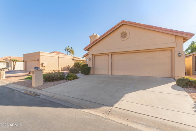 view of front of home featuring driveway, an attached garage, and stucco siding