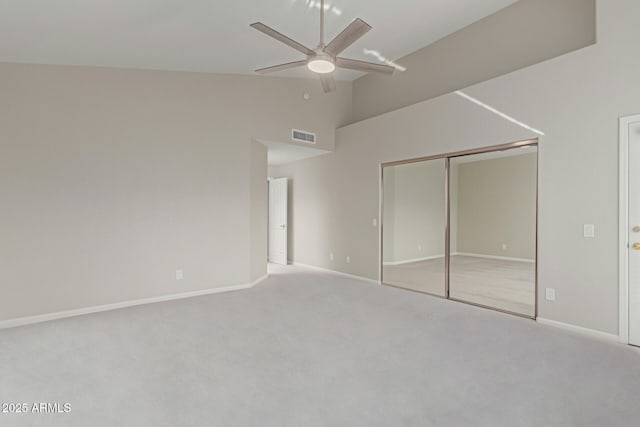 unfurnished bedroom featuring lofted ceiling, light colored carpet, a closet, and ceiling fan