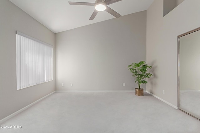 empty room featuring ceiling fan and light colored carpet