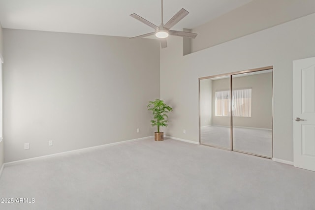 unfurnished bedroom featuring ceiling fan, a closet, and carpet flooring